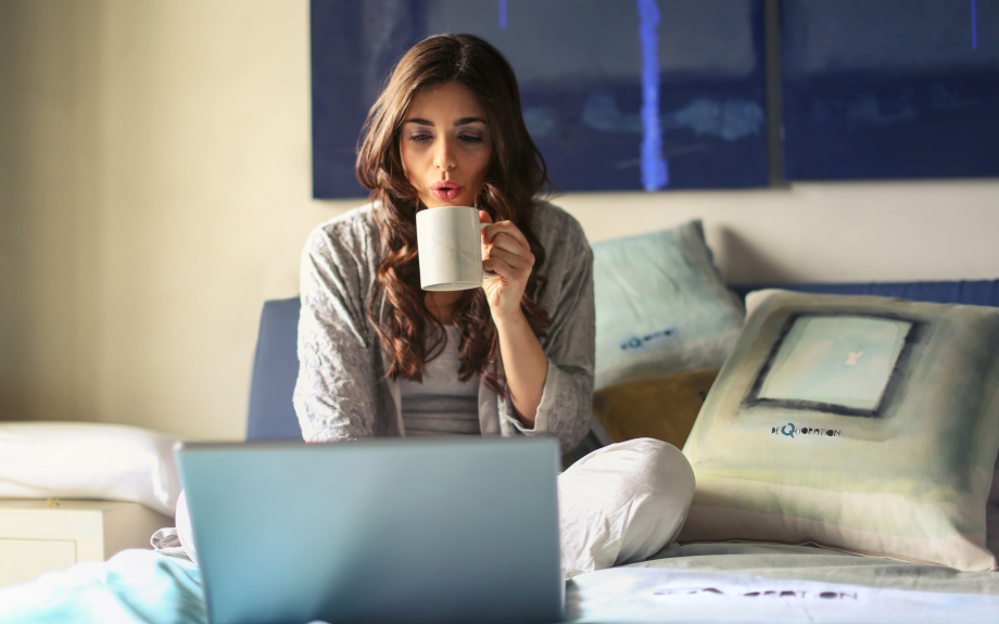 Mädchen mit Laptop auf dem Bett